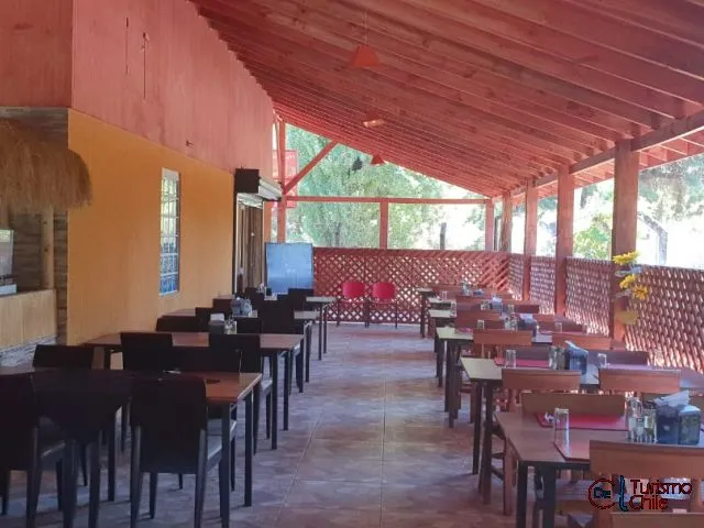 Interior del restaurante La Chinita con mesas preparadas y terraza de madera